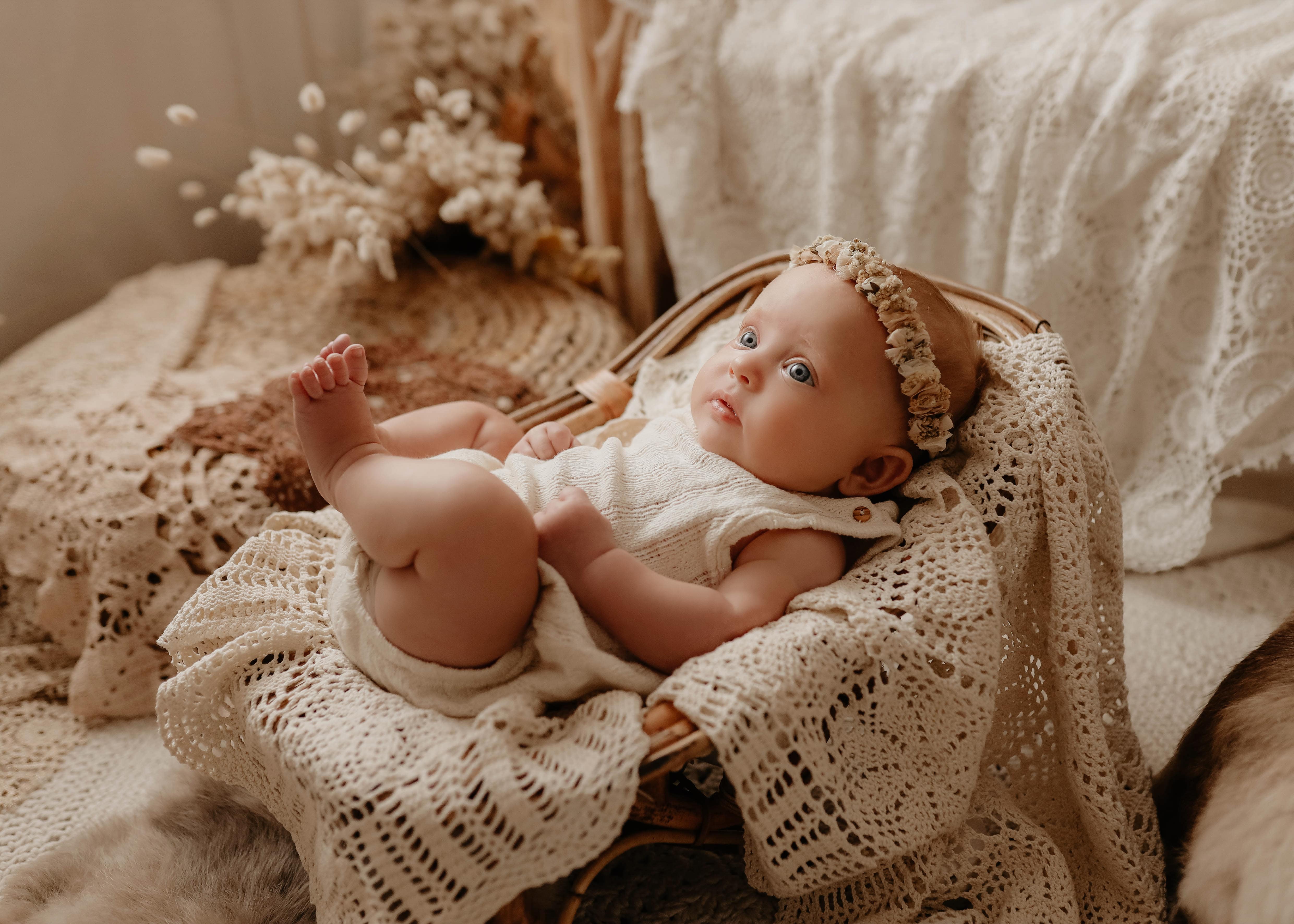 Zdjęcie przedstawiające małe dziecko podczas niemowlęcej sesji fotograficznej boho